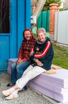 Mature russian married couple hugging and holding a dog
