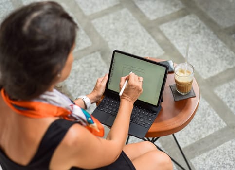 Young woman making financial planning in the tablet with stylus