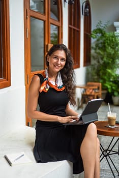40 years old brunette business woman working with a tablet and looking at camera