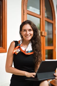 40 years old brunette business woman working with a tablet and looking at camera