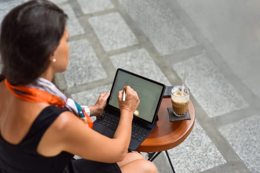 Young woman making financial planning in the tablet with stylus