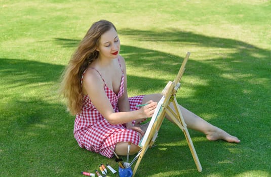 Young artist woman holding a jar with paint brushes and easel close to sea and palms in summer