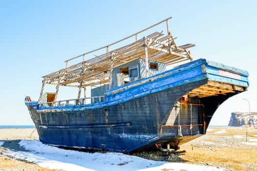Abandoned North Korean fishing schooner on the shore of the Sea of ​​Japan, Primorye, Russia.