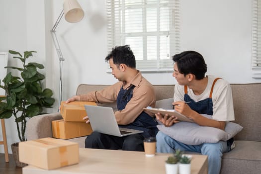 Two male entrepreneurs reviewing inventory and discussing plans for their ecommerce business while unpacking boxes in a cozy home office.