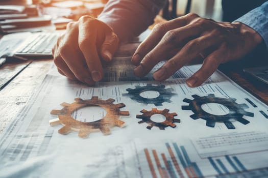 Close-up view of hands analyzing financial documents with gear overlays, symbolizing business strategy and development concepts in a collaborative workspace.