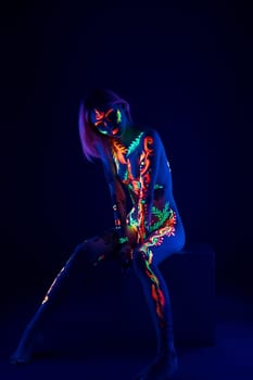 Naked girl with UV color pattern bodyart shot in blue light