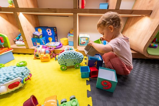 Child exploring toys and building blocks in a bright and interactive play area