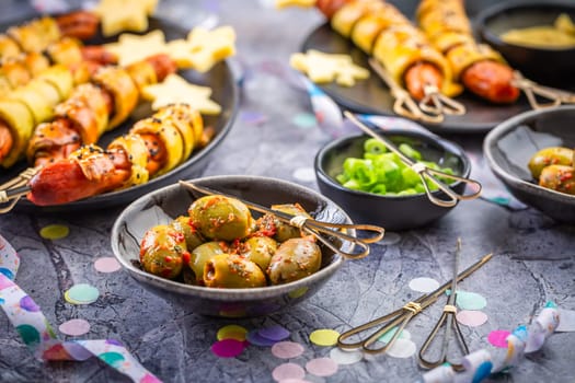 Carnival food, long sausages wrapped in yeast dough, corn dog with mustard and olives 