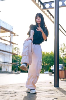 A dancer performs dynamic movements in an urban environment during golden hour near a construction site, highlighting their skills and sense of rhythm.