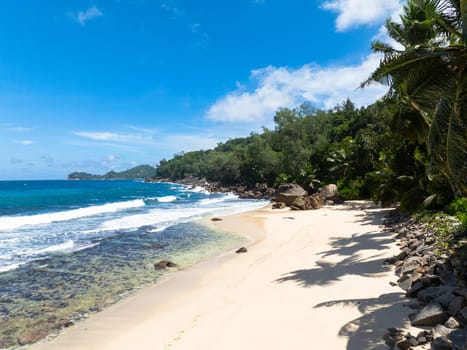 Aerial view of tropical beach and blue sea. Seychelles, Mahe. Anse Takamaka Beach.