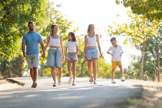 Happy family walking together on a sunny day outdoors