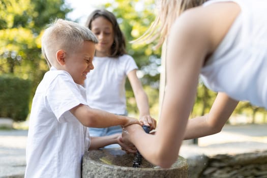 Children enjoying outdoor water fountain on a sunny day