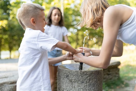 Kids having fun playing with a fountain on a sunny day