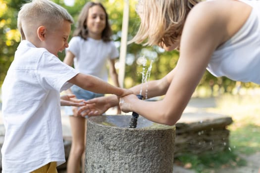 Kids having fun with water at a park fountain