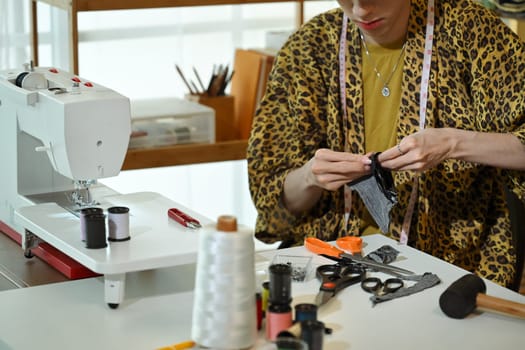 Cropped shot of stylish designer working on fabric sample in a fashion studio.
