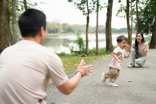 Adorable happy little boy running towards father with joyful expressions.