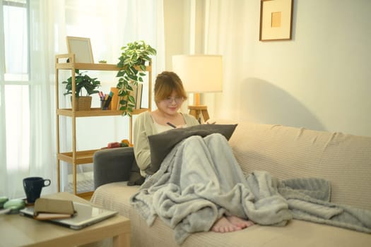 Young asian woman relaxing and writing in a planner.