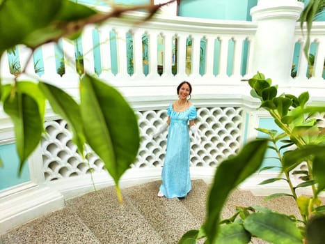 A girl dressed in a vintage gown joyfully explores the enchanting halls of a centuries-old castle.