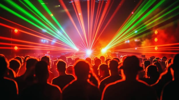 Audience enjoying colorful laser show at electronic music festival with bright lighting