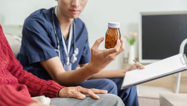 A nurse explains medication details to an elderly patient, emphasizing the importance of understanding prescriptions in a home healthcare environment.