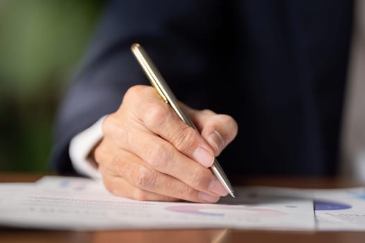 An elderly businessman diligently signing important documents highlighting the essence of professionalism and commitment in business.