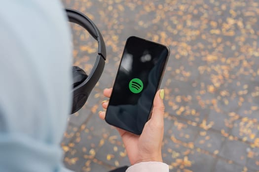 CHIANG MAI, THAILAND - January 27,2025 : A woman holding smartphone with Spotify app on screen. Spotify is a digital music service that gives you access to millions of songs.