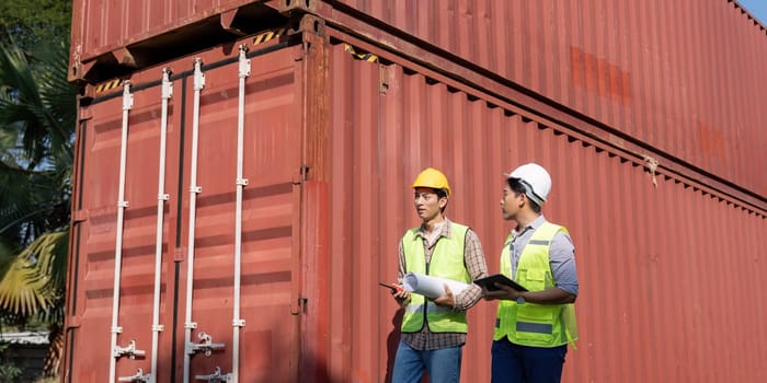 Two logistics engineers discuss container management at an industrial site ensuring efficient operations and planning.