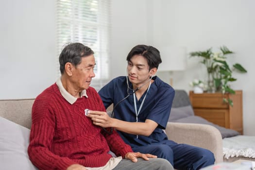 A nurse checks an elderly patient's heart rate using a stethoscope in a comfortable home environment, providing compassionate healthcare.
