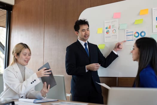 A multicultural business team engaged in a presentation of financial analysis, showcasing teamwork and effective communication in a contemporary workspace.