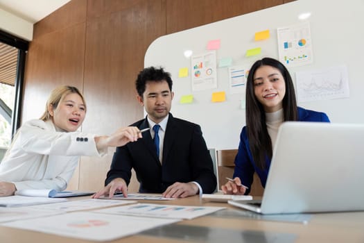 A multicultural business team engaged in a dynamic discussion about financial analysis, showcasing teamwork and strategic planning in a contemporary workspace.