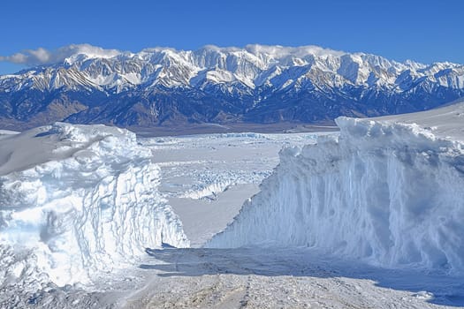 Snowy mountains rise majestically under a clear blue sky, offering stunning views.