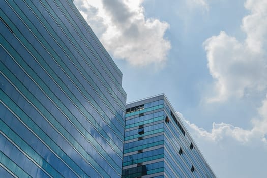 Big glass building with blue sky and white cloud