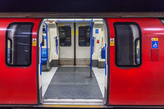 London Underground train with iconic red carriage and open doors, showcasing the modern tube interior and design