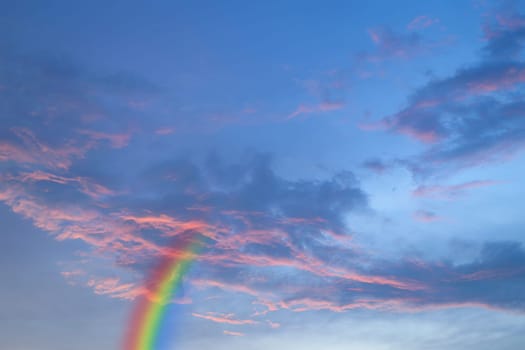 Nature cloudscape with red sky and storm cloud with rainbow