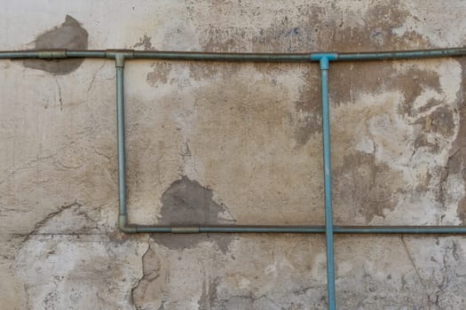 Minimalism style, Dirty green water pipe on the old wall texture background.