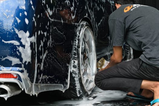 Bangkok, Thailand - June 28, 2015 : Blue car washing by hand using a foam preparation for polishing.