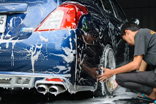 Bangkok, Thailand - June 28, 2015 : Blue car washing by hand using a foam preparation for polishing.