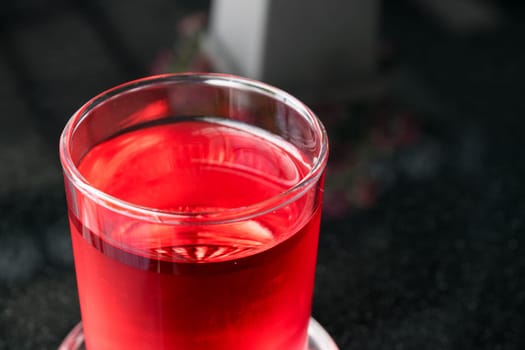 Sweet red water drink in glass on wood table