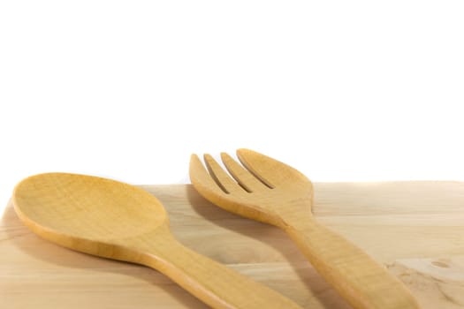 Wooden spoon and fork on wooden board isolated on white background
