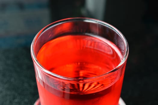 Sweet red water drink in glass on wood table