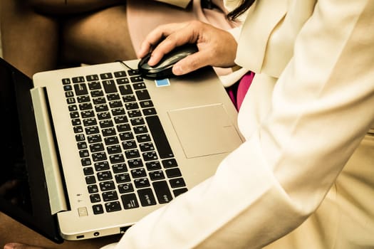 Asia woman using her computer laptop Close-up on mouse keyboard and her hand