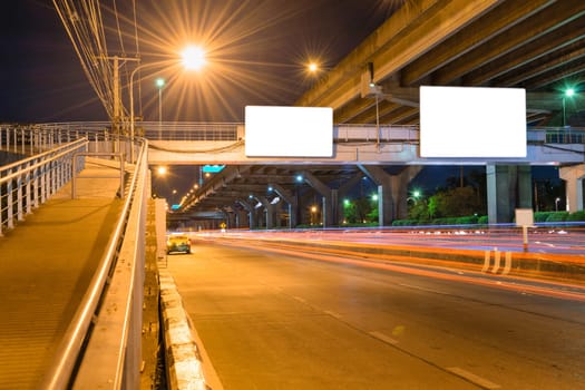 Night road long exposure with blank billboard for advertisement in Bangkok Thailand