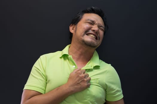 Asia man pain from disease heart attack in black background