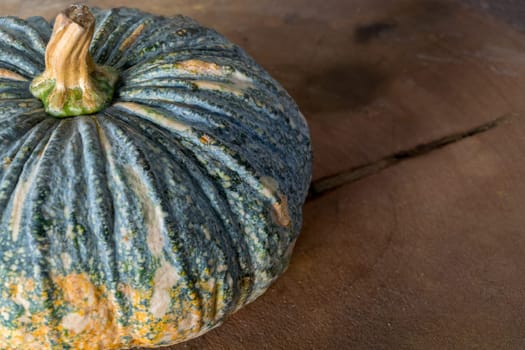 Pumpkin is a fresh vegetable have a green and yellow color on a wooden table