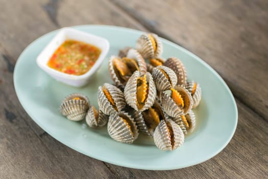 Cockles seafood boiled in dish on wood table at restaurant