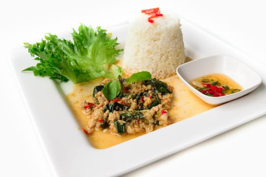 Rice topped with stir-fried pork and basil isolated on white background