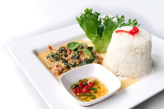 Rice topped with stir-fried pork and basil isolated on white background