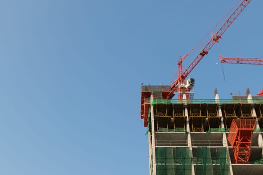 Crane with office building construction and blue sky
