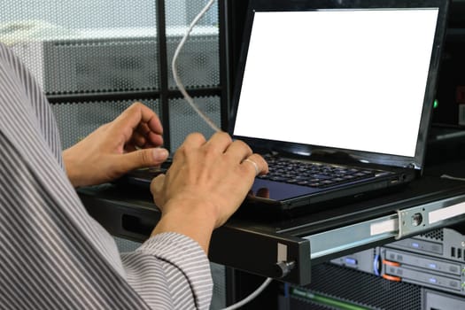 Asian man working on his computer in a data center