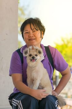 Asia woman plump body and her dog at estuary (river side and sea) when travel , process in soft orange sun light style